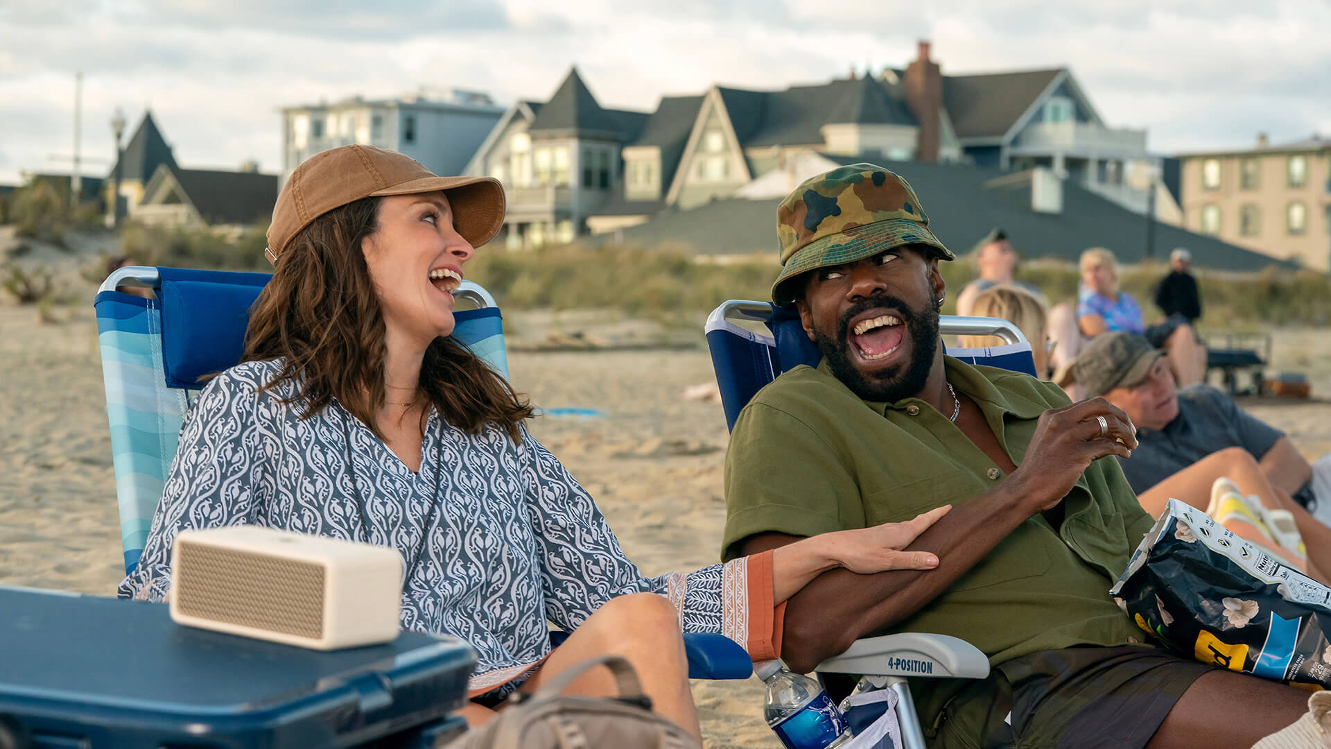 Kate and Danny laughing on the beach in The Four Seasons.