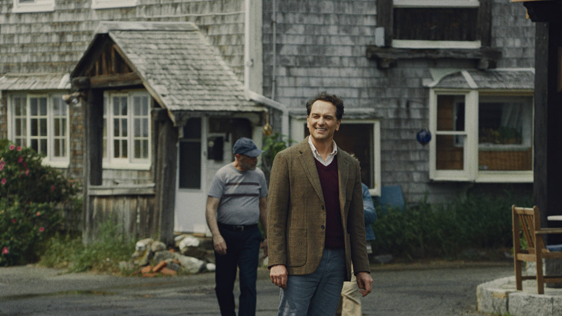 Tom standing outside of a house smiling in Widow's Bay.