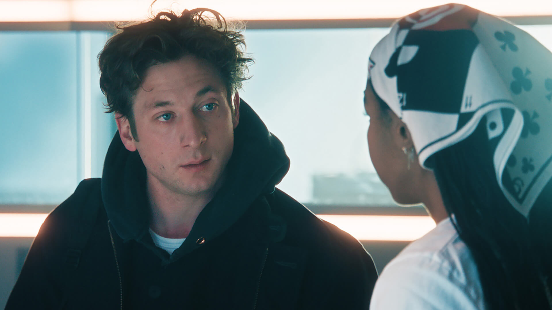 Carmy in a black hoodie talking to Sydney in The Bear.