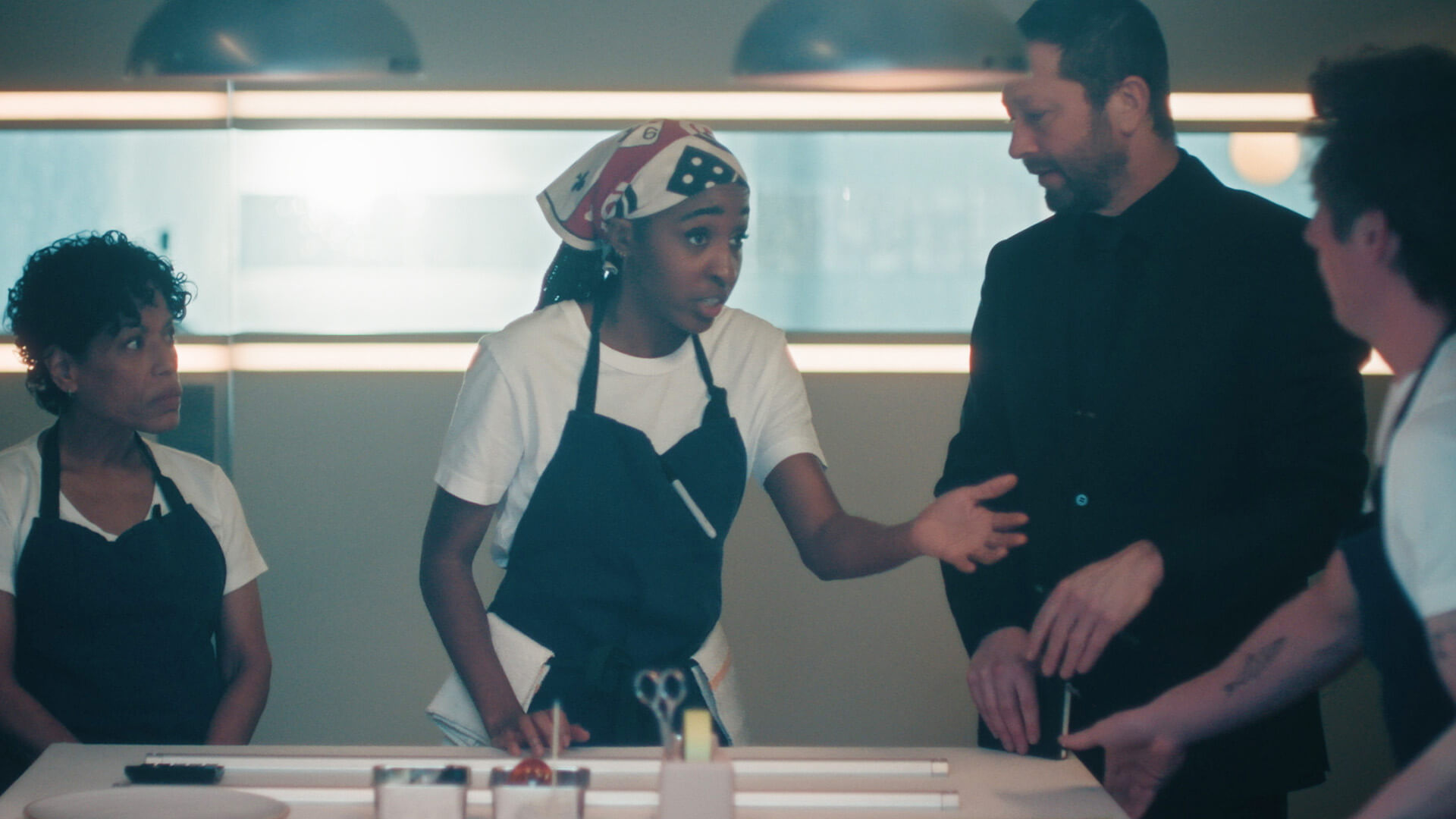 Sydney talking to the team in the kitchen on The Bear.