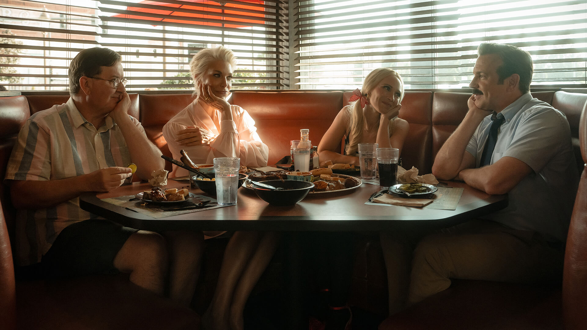 Leslie, Rebecca, Keeley, and Ted sitting in a barbecue restaurant in Kansas in Ted Lasso.
