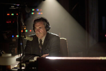 Fred Heckman wearing headphones on the radio in American Hostage.