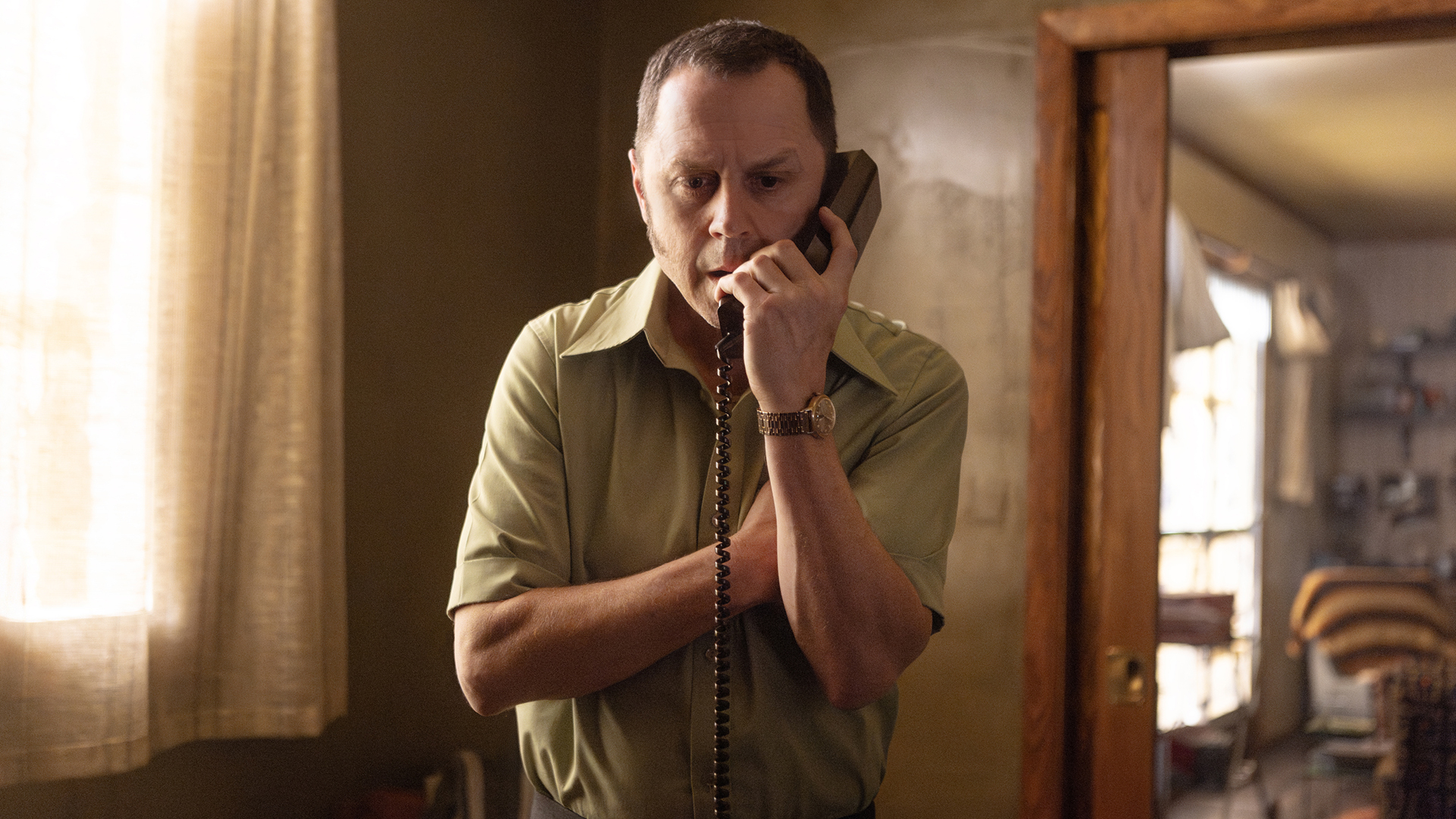 Toy on the phone in his apartment in American Hostage.