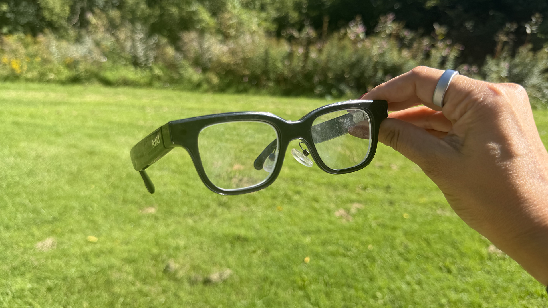 A hand holding the Rokid AI glasses