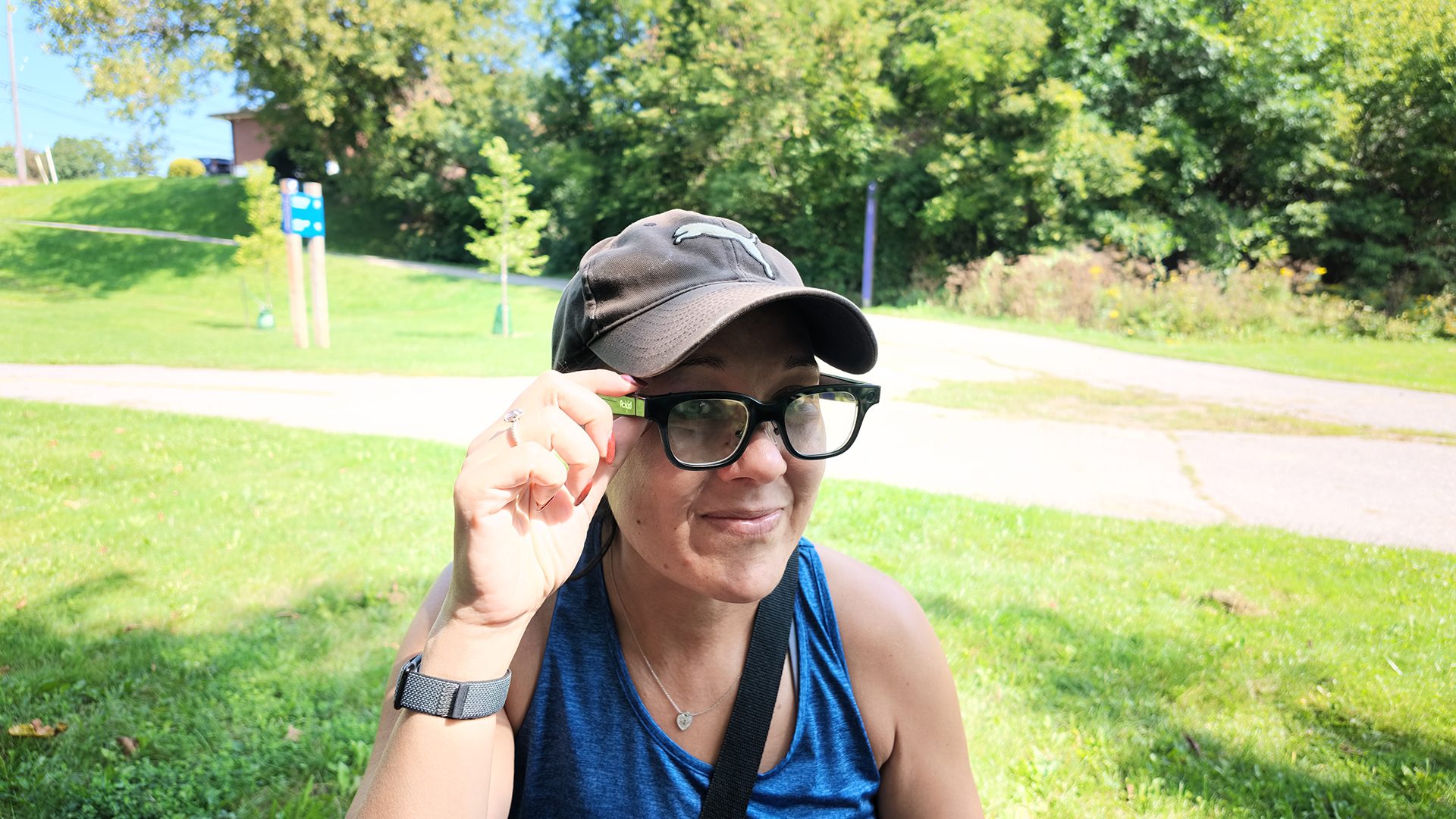 A woman wearing Rokid smart glasses outside and pressing the button.